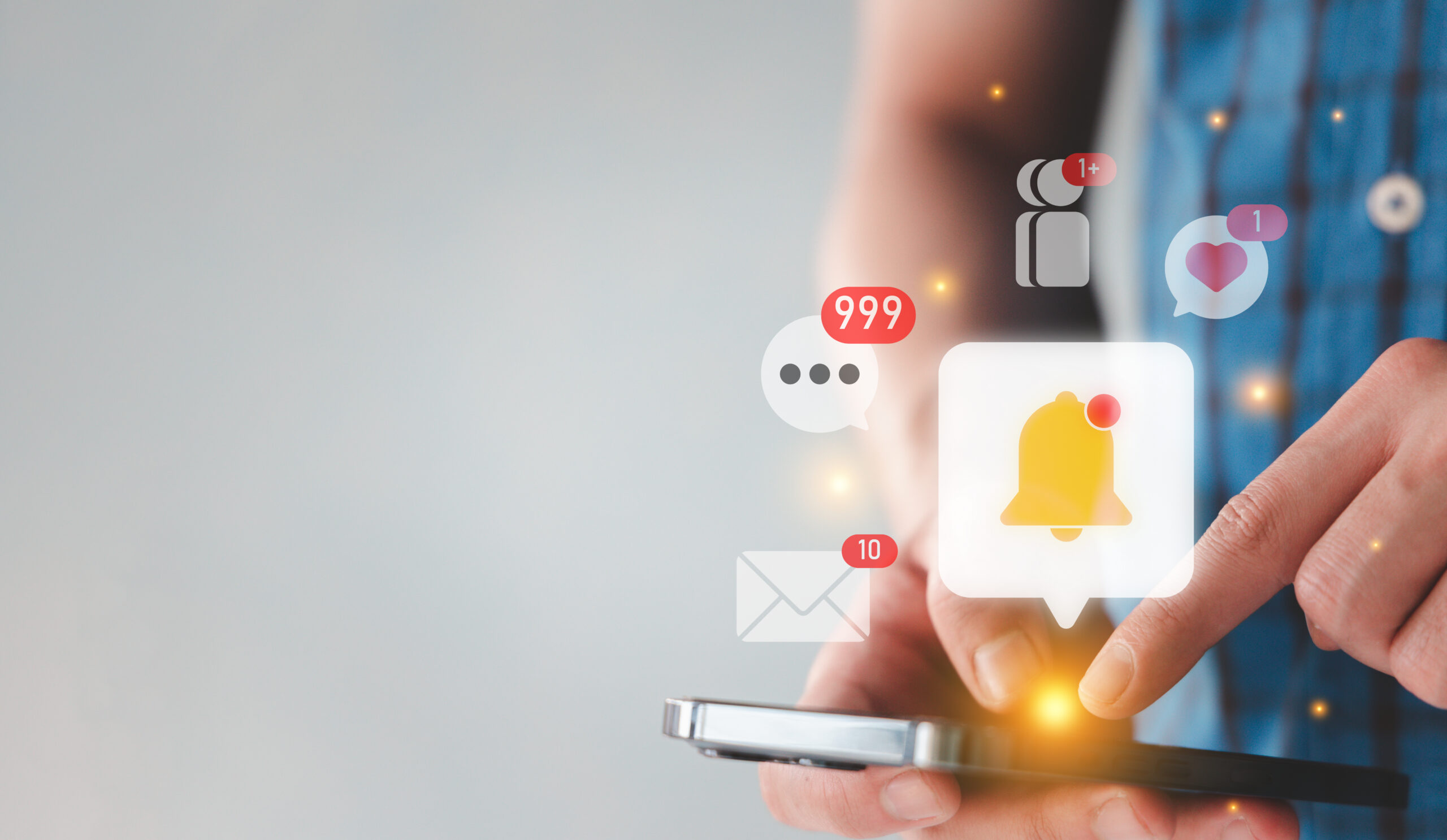 A person using a smartphone with digital notification icons, including a bell, chat bubbles, email, and likes, appearing above the screen, indicating multiple alerts and messages.